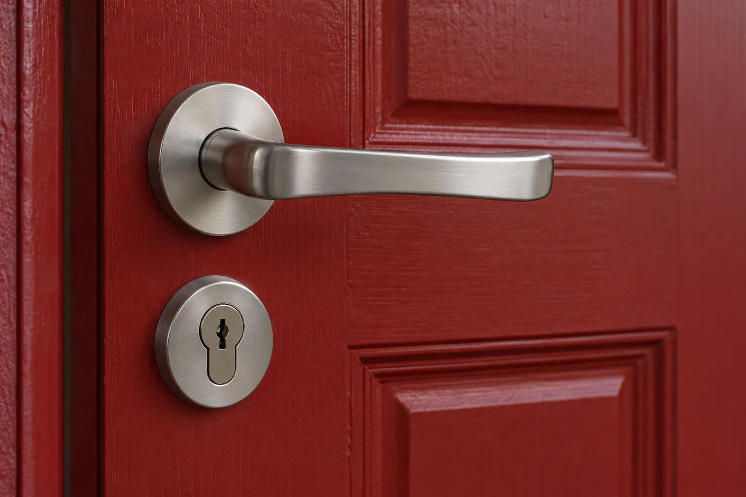 Brushed chrome handle and keyhole on a red timber door